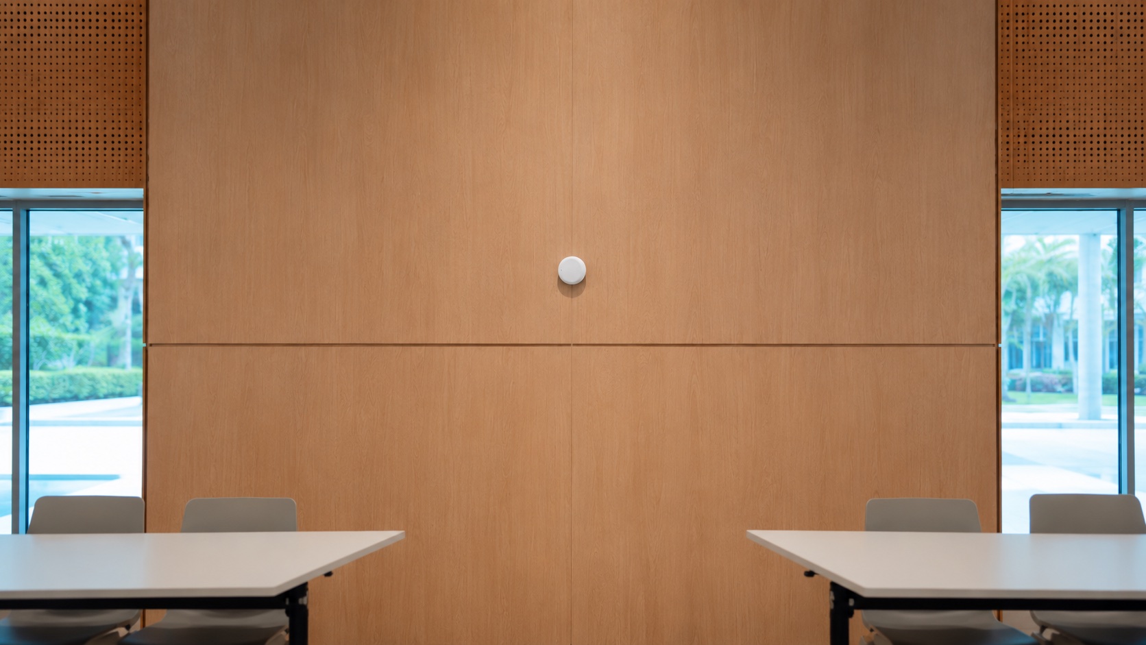 A modern classroom with a NeverMind School beacon mounted on the ceiling